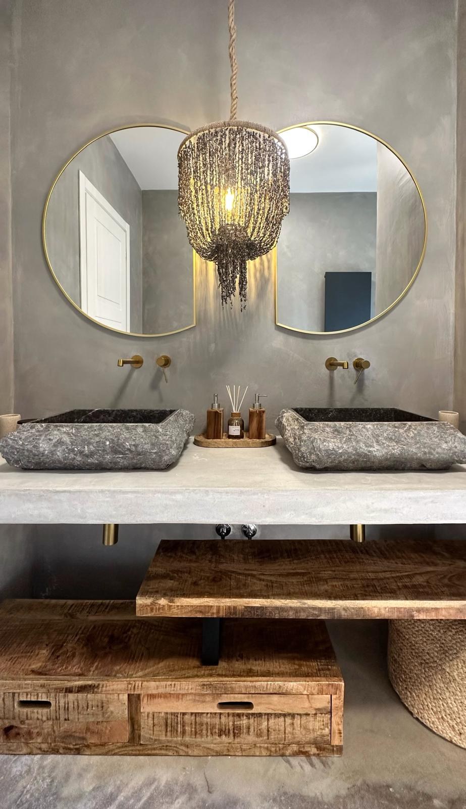 Grey stone double vanity with beaded chandelier lit